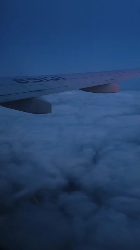 Night flight. Plane window view to the clouds. Cloudy sky above the city. Stock Footage 322809660