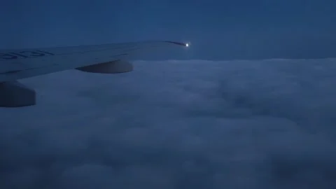 Night flight. Plane window view to the clouds. Cloudy sky above the city. Stock Footage 323291784