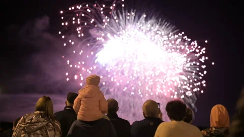 Night frame behind the crowd of people watching the fireworks. People at a Stock Footage