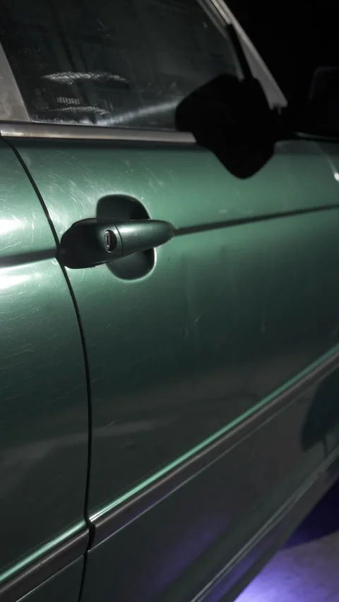 Night frame from the side of the green car that includes the door and the handle Vidéo 257017519