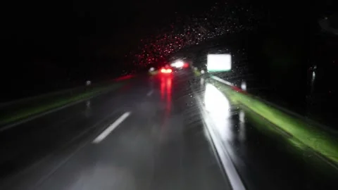 Night highway driving view through windshield light rain on glass glowing tailli Stock Footage 310485869