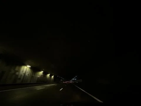 Night highway view from car window with straight lanes, tunnel walls lit by 스톡 사진