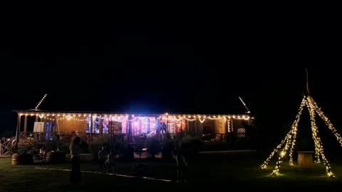  at night the house glows with lights in which people dance Stock Footage 253620878