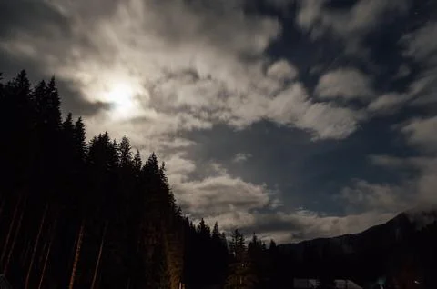 Night image of the sky with dense layers of clouds and the moon. Stock Photos