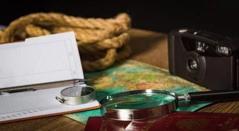 Night inspection of an old map with a compass and a magnifying glass by the l 스톡 사진