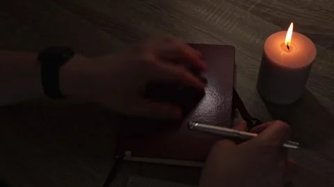 Night journaling - closing notebook and blowing out candle Video stock 338193289