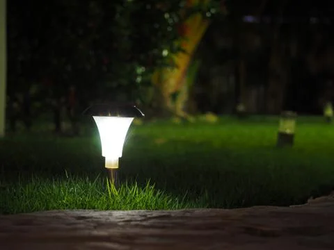 Night lantern in the grass in the hotel. Powered by solar panels. Stock Photos