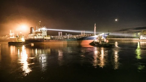At night, in the light of a powerful searchlight, the ship еnter  the dock. Stock Footage 86411364