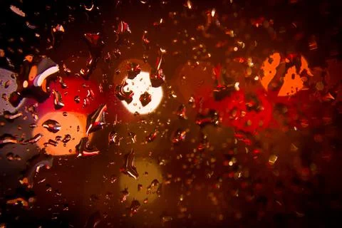 Night lights outside the window. Raindrops on the window. Stock Photos
