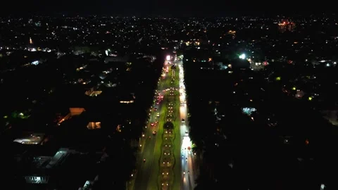 Night lights streak across a roundabouts central garden. Stock Footage 340183087