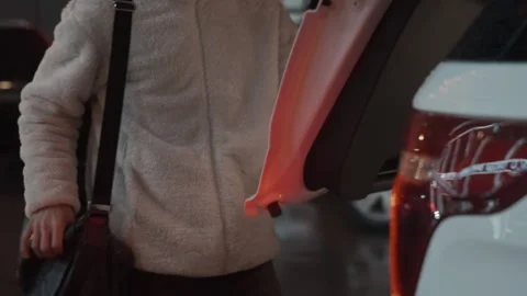 In the night a man opens trunk, takes off leather bag and puts it in the car Stock-Footage 195700744