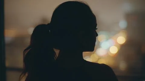 Night model looking panoramic window at dark flat back view. Woman thinking Stock Photos