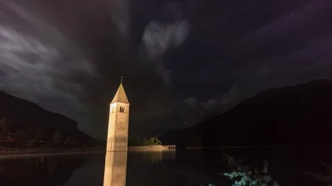 Night Motion Timelapse of Submerged Bell Tower in Lake Resia Curon South Tyrol Vídeos de archivo 345045829