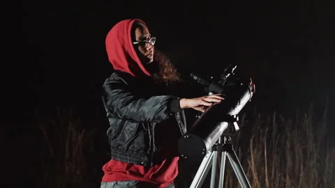 Night observer studies celestial patterns. Individual with beard surveys night Stock Footage 329801665