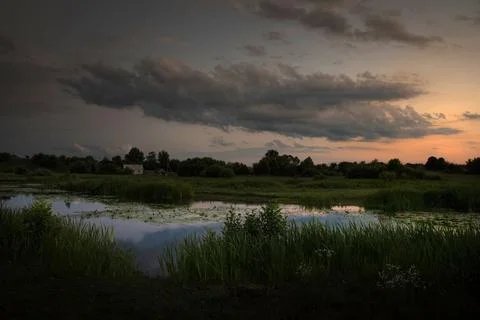 Night over the river. Clouds reflect on the surface of the water. The last re 写真素材