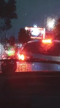 Night Rain Traffic Jam Through Car Windshield with Blurred City Lights Stock Photos