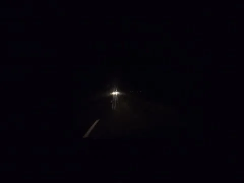 Night road from the front side illuminated by car headlights. Stock Footage 221789131
