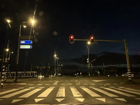 Night road intersection with traffic lights and blue direction signs for S114 Stock Photos