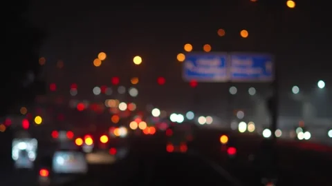 Night Road Scene with Blurred Vehicle Lights and Urban Atmosphere Stock Footage 325528989