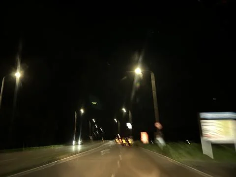 Night road view through modern arch passage with glowing streetlights and Stock Photos