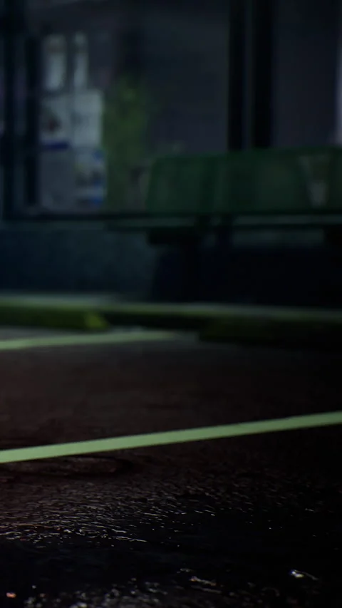 Night scene of an empty street with a green bench nearby and wet pavement Stock Footage 334172568