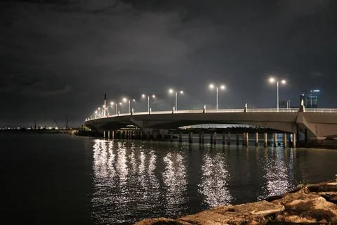 Night scene features illuminated bridge over calm water Stock Photos
