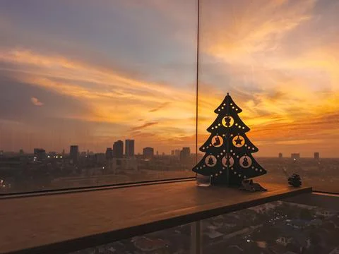 Night scene featuring silhouetted tree and city skyline at sunset Stock Photos
