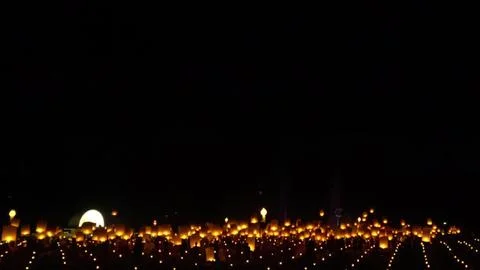Night scene with glowing lanterns floating above the dark sky Stock Photos