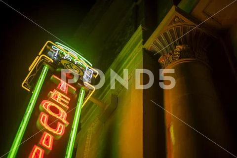 Night Scene Of Green And Orange Bar Neon Sign From Below Stock Photos
