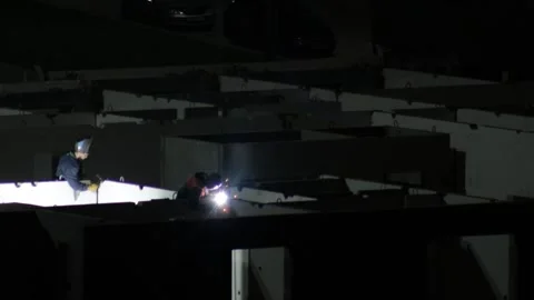 Night scene showing worker in protective mask performing welding process Stock Footage 329213913