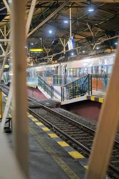 Night scene on the train station platform featuring a steel canopy structure Stock Photos