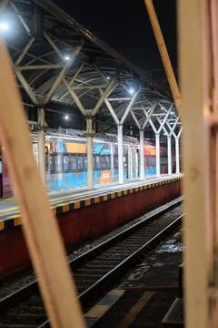 Night scene on the train station platform featuring a steel canopy structure Stock Photos