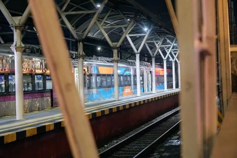 Night scene on the train station platform featuring a steel canopy structure Stock Photos