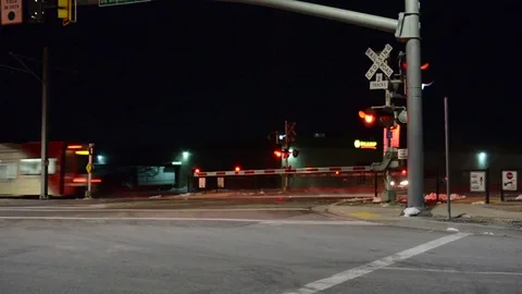 Night Shot of Light Rail Train Speeding Through Crossing. HiFi Stereo Audio. Vídeo Stock 84967484