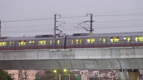 Night shot of a metro train with lights on crossing on an overhead track system Stock Footage 141838857