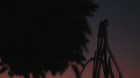 A night shot with a roller coaster on the background of a dark post-sunset sky Stock Footage 229331654