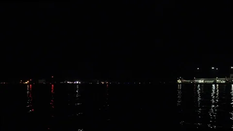 Night shot of a shore with blinking lights and reflections Stock Footage
