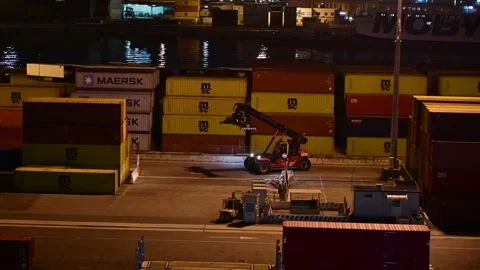 Night shot of tele handler  tractor driving through containers of a port Stock Footage 223735553