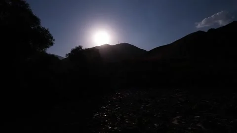 Night silhouette on Chalus Road frames a bright moon behind dark trees and Stock Footage 343907583