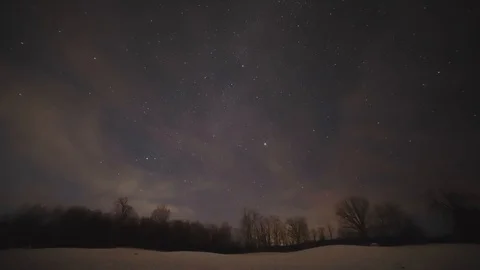 Night Sky Milky Way Timelapse with clouds passing over a snowy field Stock Footage