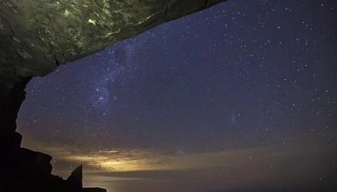 A night sky seen through a cave opening Stock Photos