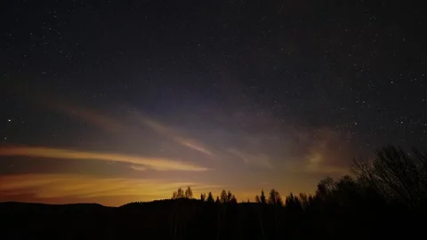 Night sky timelapse with moving clouds and rising moonlight over forest horizon Stock Footage 327128008