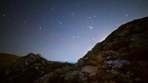 Night sky timelapse over rocky landscape with stars and celestial bodies visible Vídeos de archivo 337726155