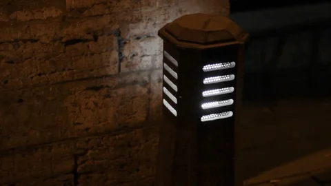 Night small lamp near the path. stone wall building at dark. illumination 스톡 동영상 120576328