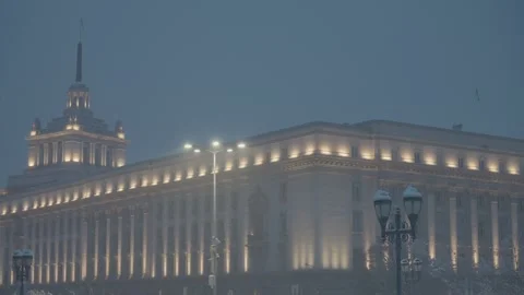 Night snowfall in Sofia with the architectural building of the parliament Stock Footage 297959925