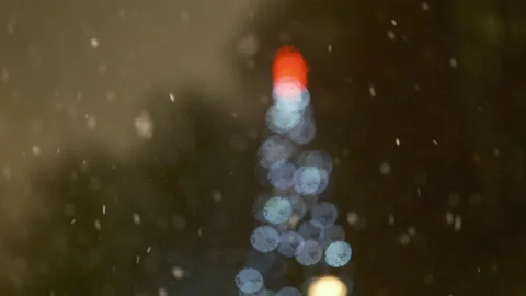 Night snowstorm with falling snow, defocused Christmas tree glowing background Vidéo 325194367