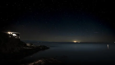 Night starry sky time lapse with house on the ocean, galaxy, ocean night Stock Footage 262300654