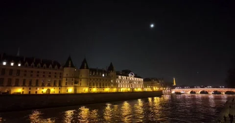 Night static shot of Palais de la Cité, Seine River boat, and Eiffel Tower Stock Footage 319607398