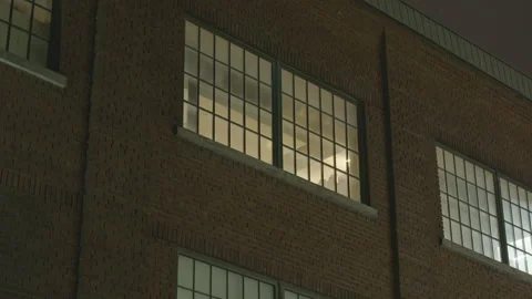 Night street level view of generic industrial brick building loft window Vídeos de archivo 231356341