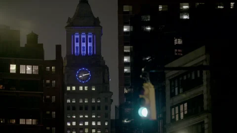 Night time cityscape with clocktower lit up in blue light in background. Stock Footage 257476803